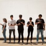 Group of teenagers looking at smartphones — teen slang 2026 guide for parents