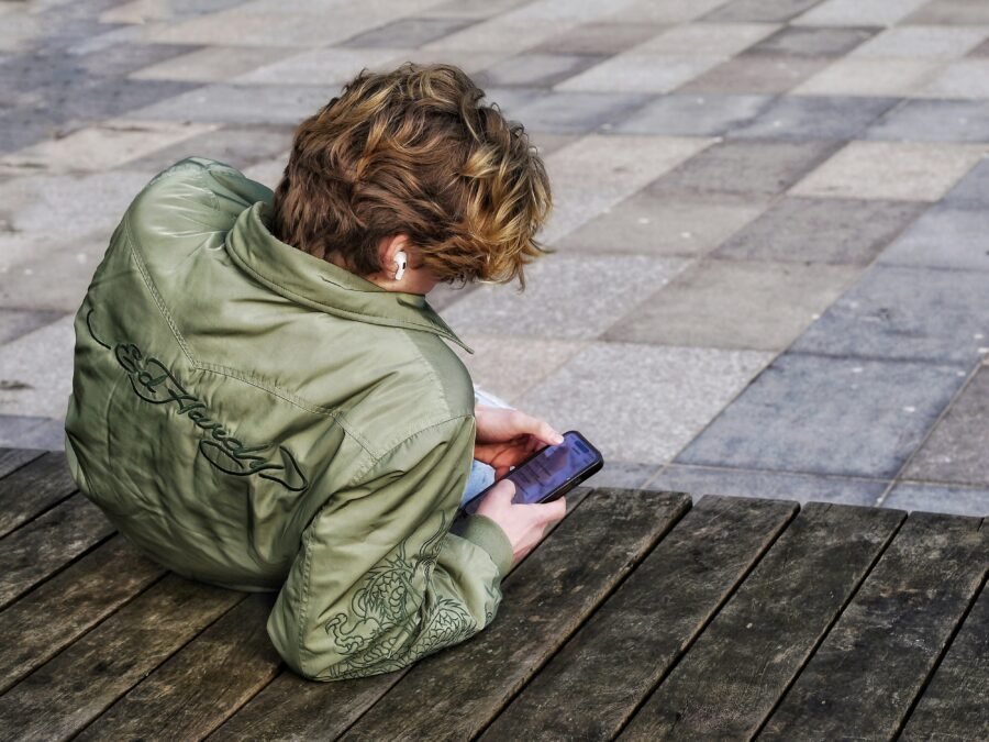 Teenager texting on a smartphone — teen slang text abbreviations every parent should know