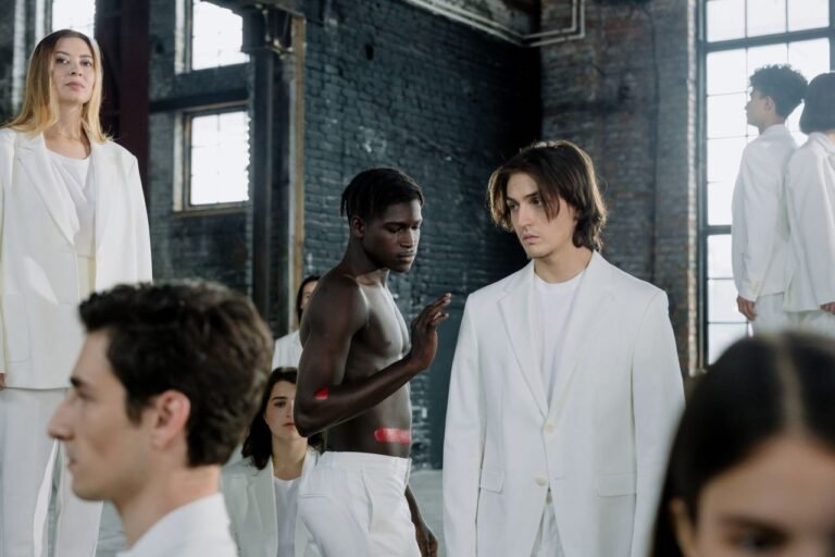 Models in a fashion shoot wearing white outfits in an industrial space.