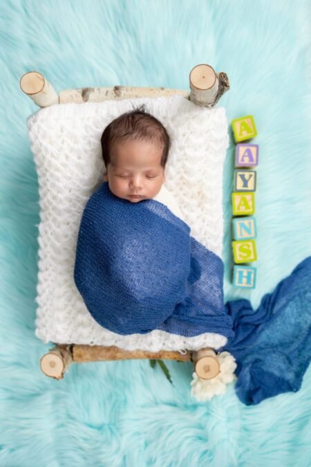 Avery baby name meaning illustrated by a newborn with wooden name blocks
