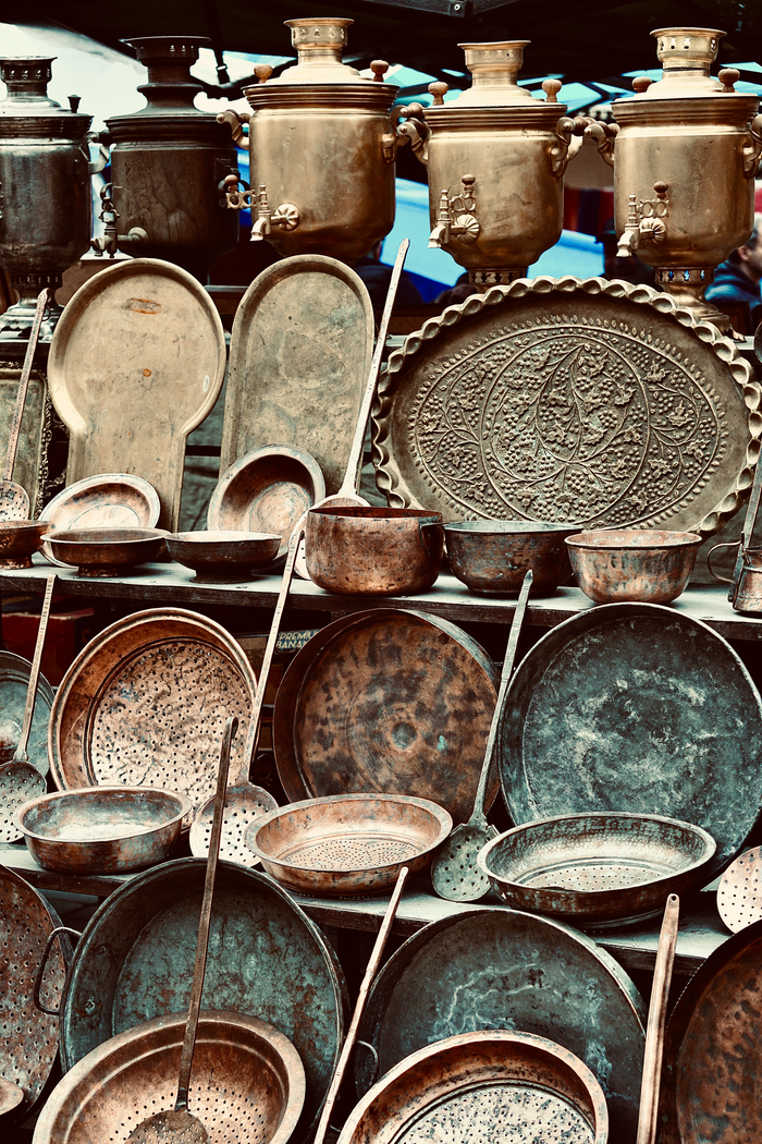 Collection of vintage metal cookware and samovars showcasing a rustic, antique feel.